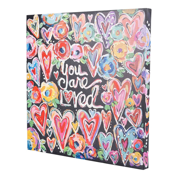 Canvas print with colorful hearts and flowers and the text 'You are loved' on a black background.
