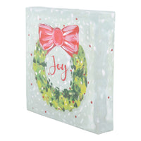 Decorative canvas with a Christmas wreath and bow design on a light blue background.
