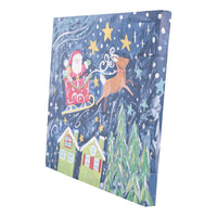 Canvas print with Christmas scene featuring Santa Claus, reindeer, and houses on a blue background.
