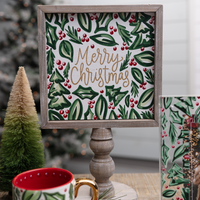 Framed Christmas-themed artwork with 'Merry Christmas' text, surrounded by festive decor.