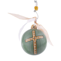 A green spherical ceramic ornament with a dainty cross design in a different color, hanging from a ribbon.
