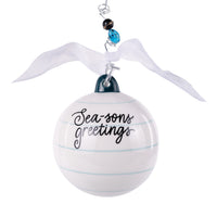 White ornament with 'Sea-sons greetings' text, ribbon, and beads on a white background