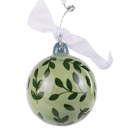 Green glass ornament with leaf pattern on a white background