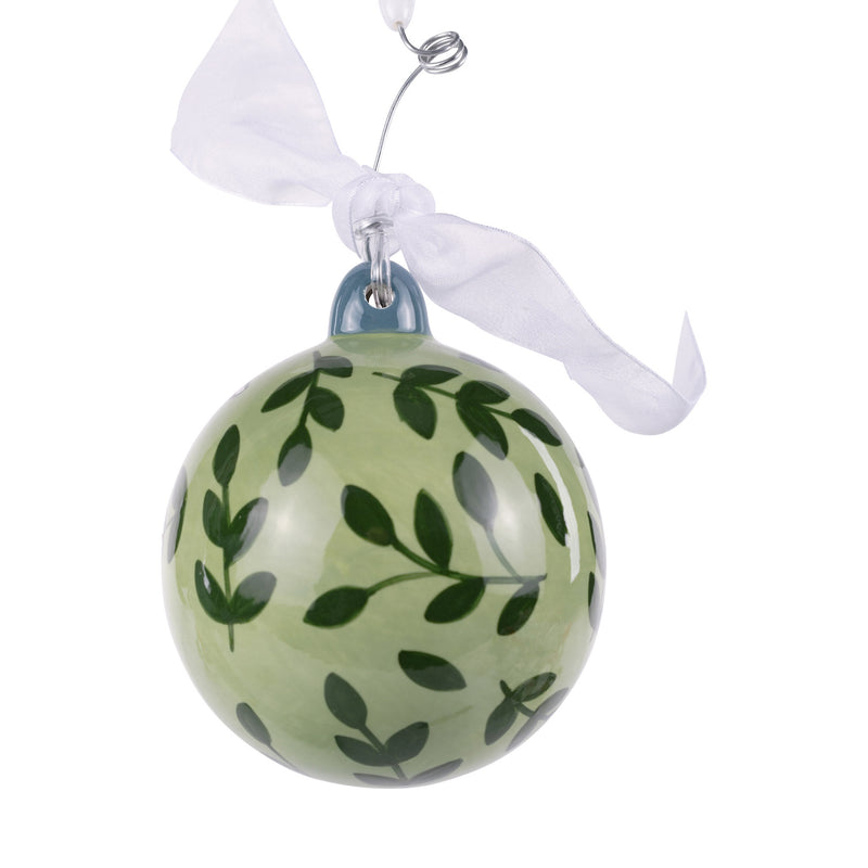 Green glass ornament with leaf pattern on a white background