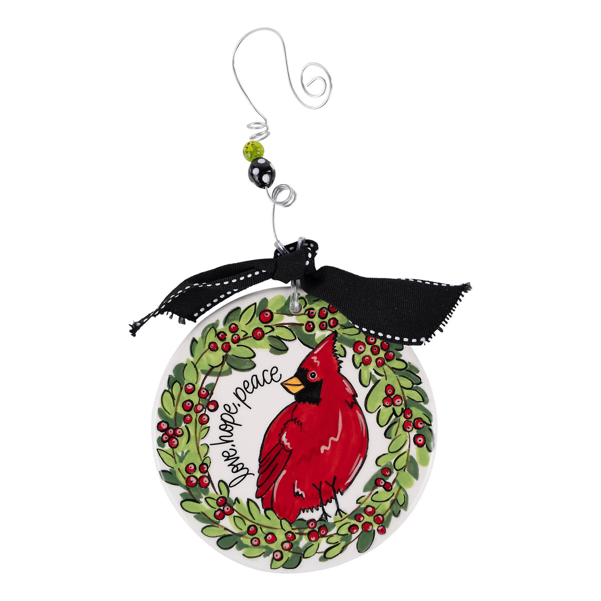 Christmas ornament with a red cardinal bird, holly leaves, and berries on a white background.