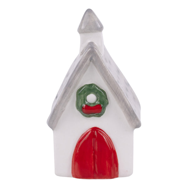 Small decorative house with a red door and green wreath on a white background