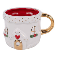 Decorative mug with a house design, gold handle, and red interior on a white background