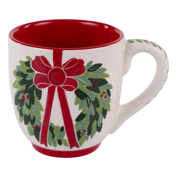 White mug with red interior, green wreath with red bow design on a white background