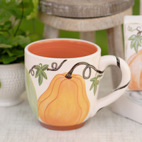 Ceramic mug with pumpkin design on a table outdoors