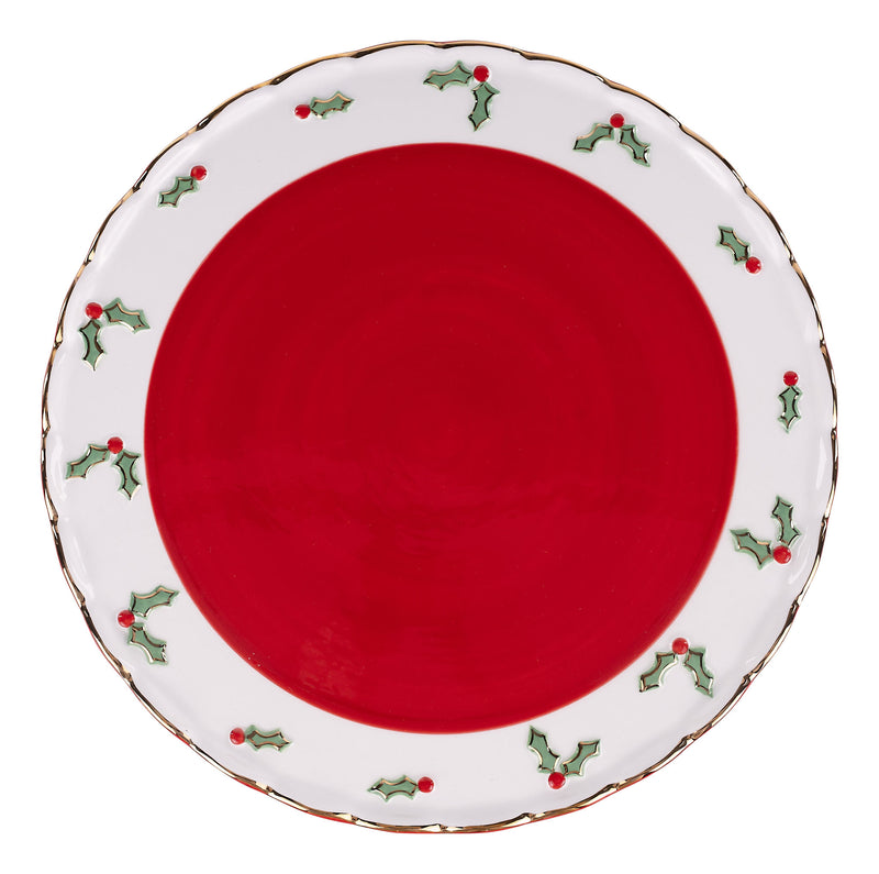 Red cake stand with decorative white rim featuring holly designs on a white background