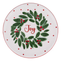 Decorative plate with a green wreath and red berries on a white background