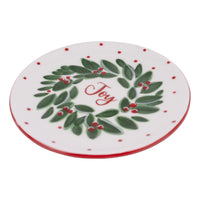 Round plate with a green wreath and 'Joy' text on a white background