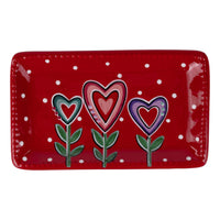 Red rectangular plate with heart-shaped flowers on a white background