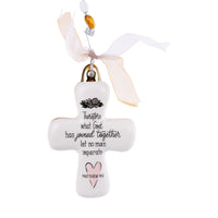 A white ceramic cross-shaped ornament with a floral design, a pink heart, and black scripted text. It is adorned with a clear crystal at the top and has a white ribbon for hanging.