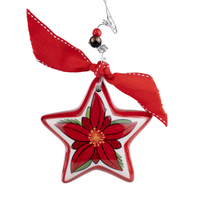 A ceramic star-shaped ornament with a vibrant red poinsettia design, accented with green leaves and a yellow center, hanging from a red ribbon.