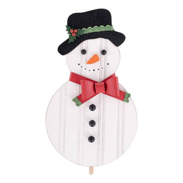 Wooden snowman decoration with a black hat, red bow tie, and white face on a white background