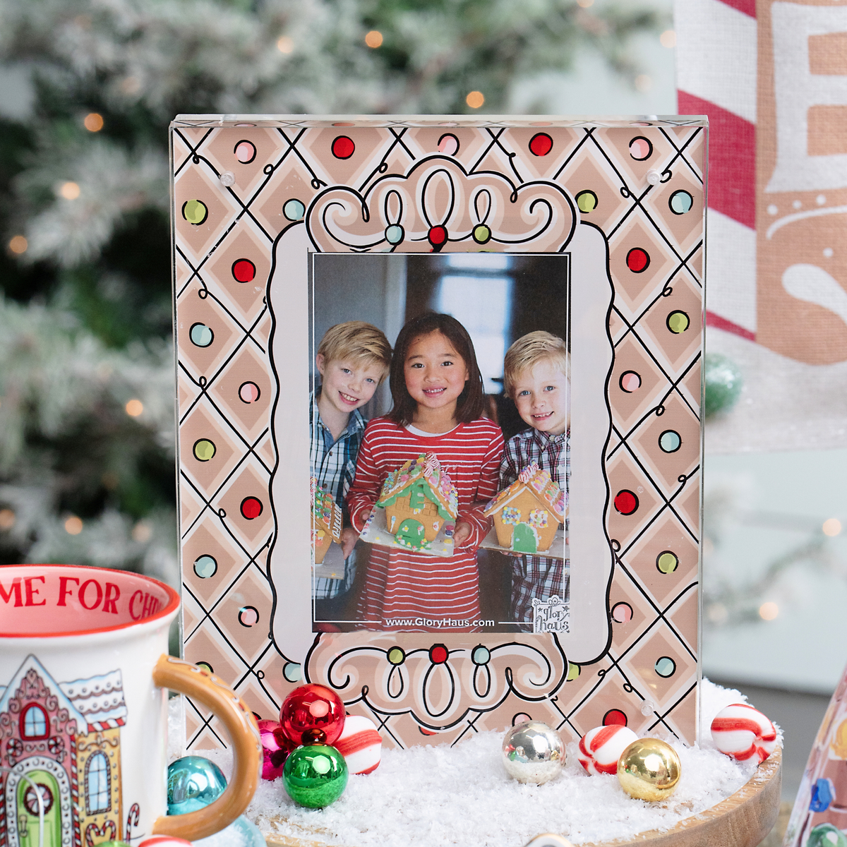 Decorative photo frame with a Christmas theme, featuring children holding gingerbread houses, on a festive background.