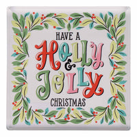 Decorative napkin weight with 'Have a Holly Jolly Christmas' text surrounded by holly leaves and berries.