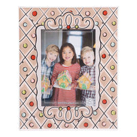 Decorative photo frame with a family holding gingerbread houses inside