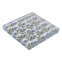 Patterned napkin weight with blue and green floral design on a light 