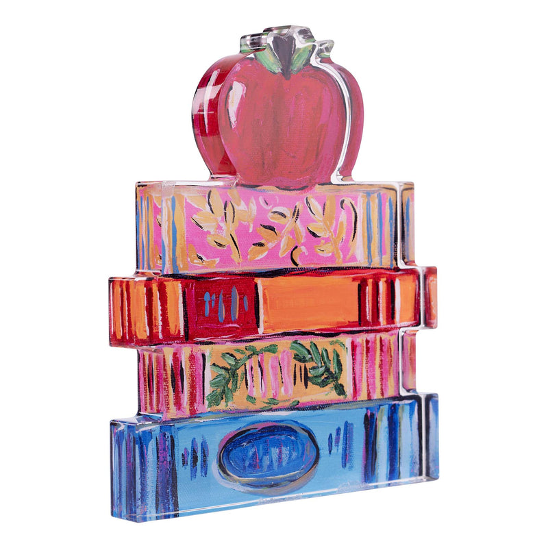 Colorful acrylic sculpture of stacked books with an apple on top against a white background