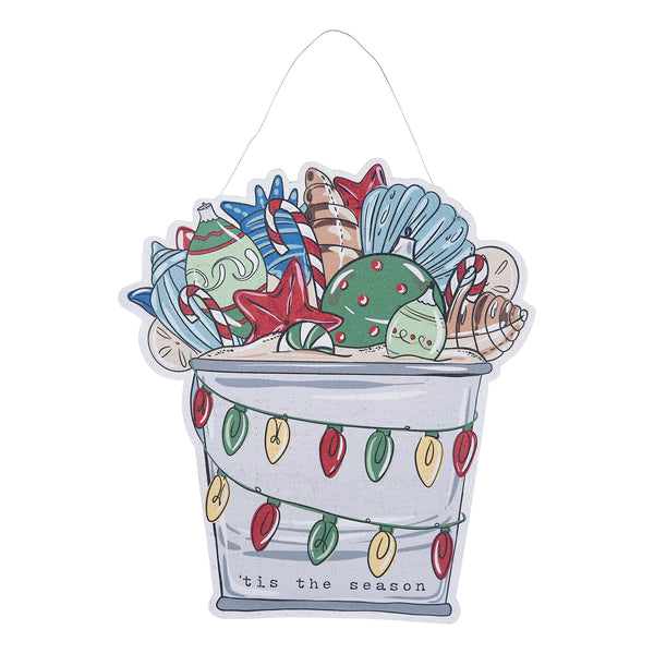 A door hanger featuring a beach bucket filled with seashells, with one side having the text 'Welcome' and the other side 'Tis the Season'.